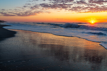 Sunrise Reflections on Smooth Beach Sand