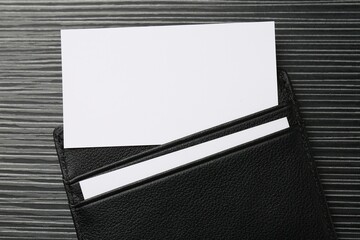 Leather business card holder with blank cards on grey table, top view
