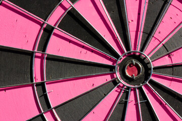 Pink and black round shape dart close up. Dartboard center ring with a red eye. Opportunity, luck,...