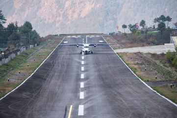 An aircraft landing on the runway in Lukla airport the most dangerous airport in the world in...
