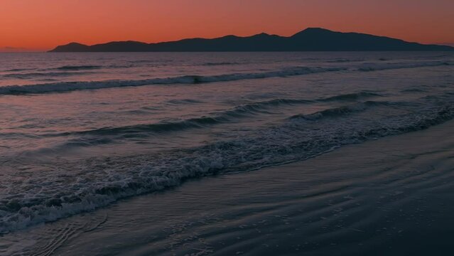 Aerial: Sunset over ocean looking out to Kapiti Island. Paraparaumu, Wellington, New Zealand.