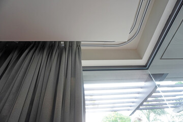 Curtain rails in bedroom corner. Double curtain rails and ceiling board design for room corner, Ideas for bedroom design. Selective focus