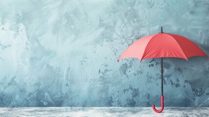 Red umbrella against textured blue wall background