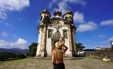 Holidays in Ouro Preto, Brazil. Rear view of traveler girl in Ouro Preto visiting Saint Francis of Assisi church in Minas Gerais state, Brazil. UNESCO world heritage.