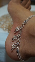 The anklet, crafted from shimmering silver, features intricate designs that capture the imagination...