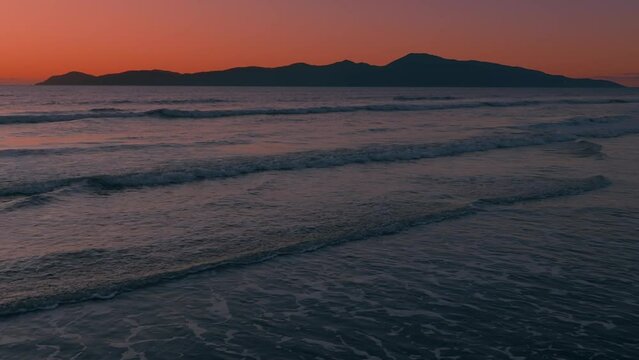 Aerial: Sunset over ocean looking out to Kapiti Island. Paraparaumu, Wellington, New Zealand.