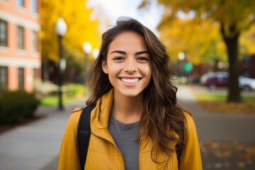 A Radiant Young Woman Smiling Confidently as She Stands Before the Bustling Student Apartment Complex on a Bright Autumn Day