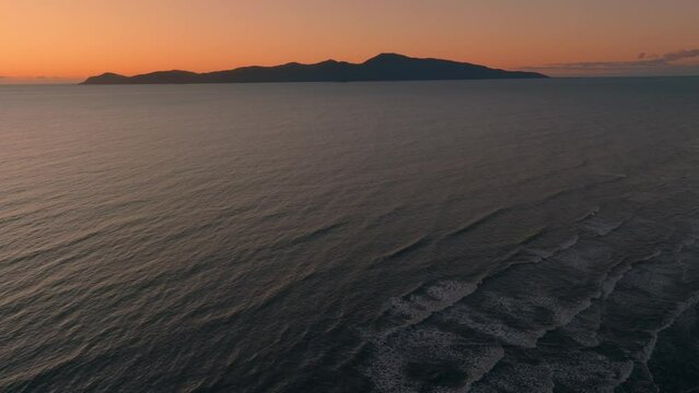 Aerial: Paraparaumu beach and Kapiti Island at sunset, wellington, New Zealand.