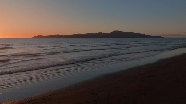 Aerial: Paraparaumu beach and Kapiti Island at sunset, wellington, New Zealand.
