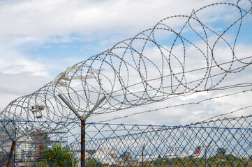 Barbed wire fence. Razor wire. Restricted area. Airport protection.