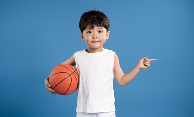 Portrait of asian kid boy wearing tank top and posing on blue background