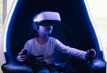 Little boy playing virtual reality simulation games.