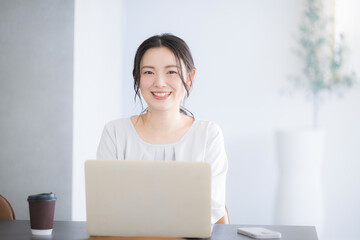 Young cute woman smiling for the camera while at the computer Front