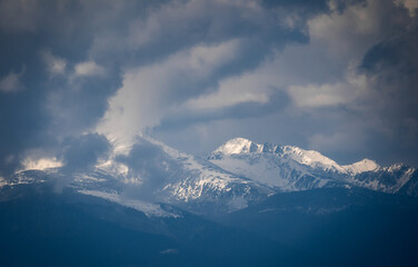 Snowy mountain range with blue sky and clouds. Retezat Mountain in The Carpathians.