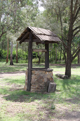 Rustic wishing well surrounded by trees at the Tipperary Flat Rest Area in Nanango, Queensland, Australia