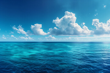 Endless ocean with sun-kissed blue sea meets cloud-strewn sky revealing vast azure horizon.