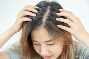 Asian woman very sad and upset looking at damaged hair, hair loss, hair thinning problem, vitamin...