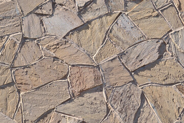 Stone-lined wall. Abstract beige stone background. Natural material, rough surface.