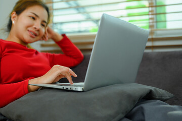 Carefree young woman working online or browsing internet on couch. People and technology concept