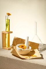 Creative photo for advertising cosmetic with calendula extract. Test tube, glass funnel, small...