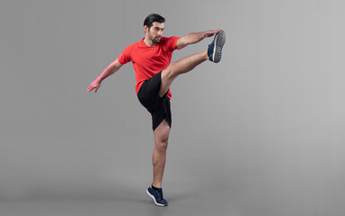 Full body length gaiety shot athletic and sporty young man with fitness in cardio exercise, kicking...