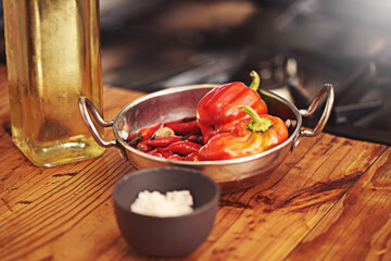 Cooking, food and vegetables in kitchen for dinner, supper and lunch meal prep in home. Recipe, diet and utensils on counter with bell peppers ingredients for wellness, nutrition and healthy eating