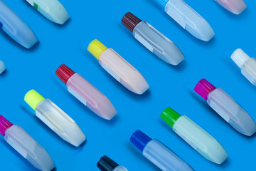 Several watercolor straws placed on a blue background all over the background
