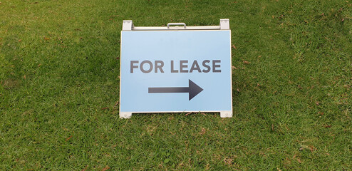 for lease, real estate sign portable A-Frame style stand outdoors on grass area with space for text