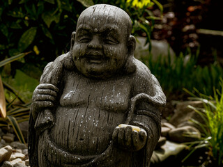 Fototapeta na wymiar Statue of a Buddhist monk in a garden, close-up
