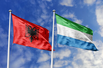 3d illustration. Albania and Sierra Leone Flag waving in sky. High detailed waving flag. 3D render. Waving in sky. Flags fluttered in the cloudy sky.