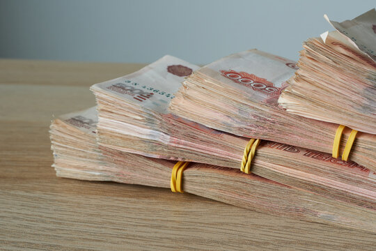 Stacks of Russian rubles on a wooden table. A shallow depth of field