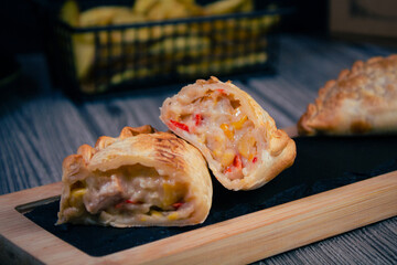 Sliced empanada with rich Argentinian filling, potatoes on a restaurant table