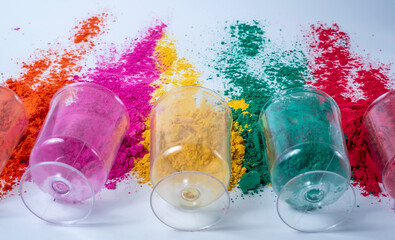 Colorful Holi powder in a glass on a white background. Holi festival concept