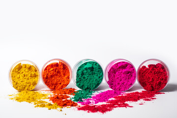 Colorful holi powder in a glass container isolated on white background.