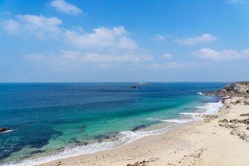 Plage de sable blanc et eaux turquoises offrant un cadre exceptionnel en Bretagne