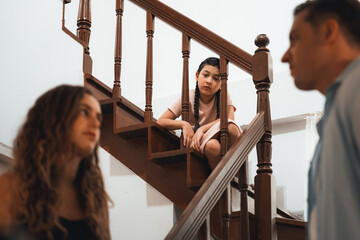 Stressed and unhappy young girl watch her parent arguing from the stair. Domestic violence at home...