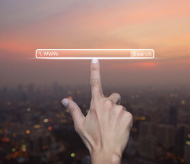 Hand pressing search www button over blur of cityscape on warm light sundown, Searching system and...