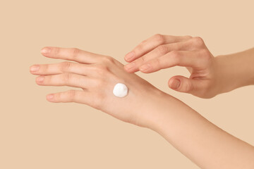 Female hands with natural cream on color background, closeup