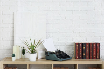 Vintage typewriter with books and plants on shelf in room