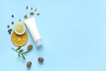 Tube of natural cosmetic product, lime and olives on blue background