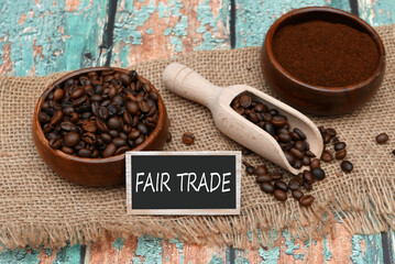 Roasted coffee beans and coffee powder with the inscription Fair Trade on a label.