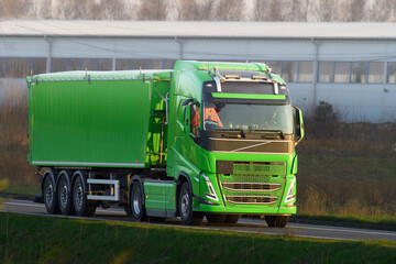 Front-side view of a truck shipping parcels and goods on the highway. European semi-trailer truck...