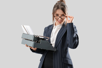 Pretty businesswoman in eyeglasses with typewriter on white background - Powered by Adobe