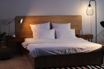 Interior of bedroom with tables and glowing lamps at night