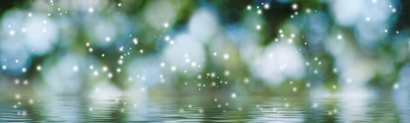  image of many white particles in the form of flares on a green blurred background with a water...