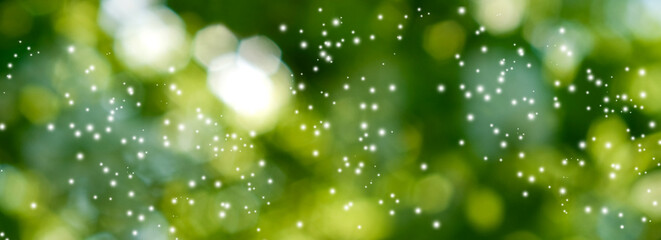 image of many white particles in the form of flashes on a green blurred background