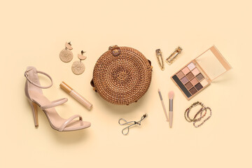 Heeled sandals, wicker bag and decorative cosmetics on beige background