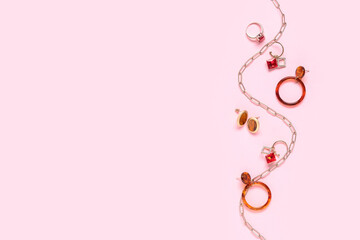 Necklace, ring and earrings on pink background