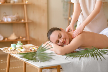Obraz na płótnie Canvas Young woman getting shoulders massage in spa salon