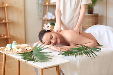 Obraz na płótnie Canvas Beautiful young woman getting back massage in spa salon